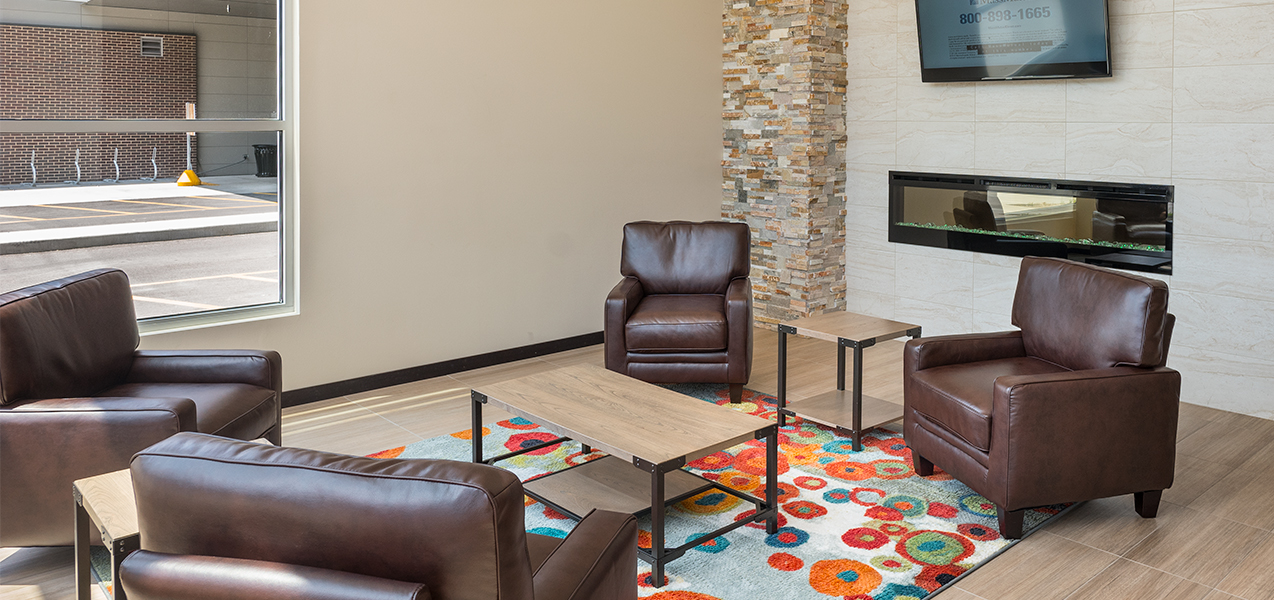 Sitting area with chairs and glass table inside the Galaxie condominium building in Madison, WI.