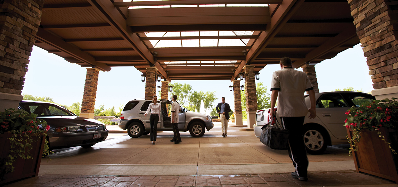 Drop off area at front entrance of the Grand Geneva Resort in Wisconsin showing cars and valets.