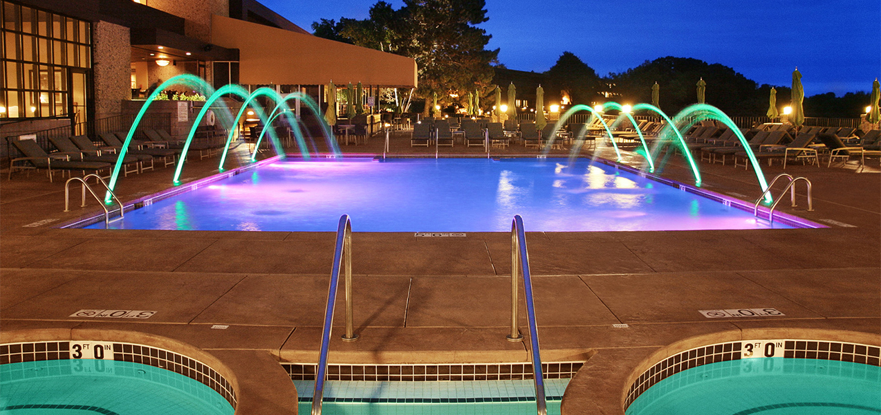 Lighted pool and fountains at night at the Geneva Resort in Lake Geneva, WI, which is a Tri-North Builders project.