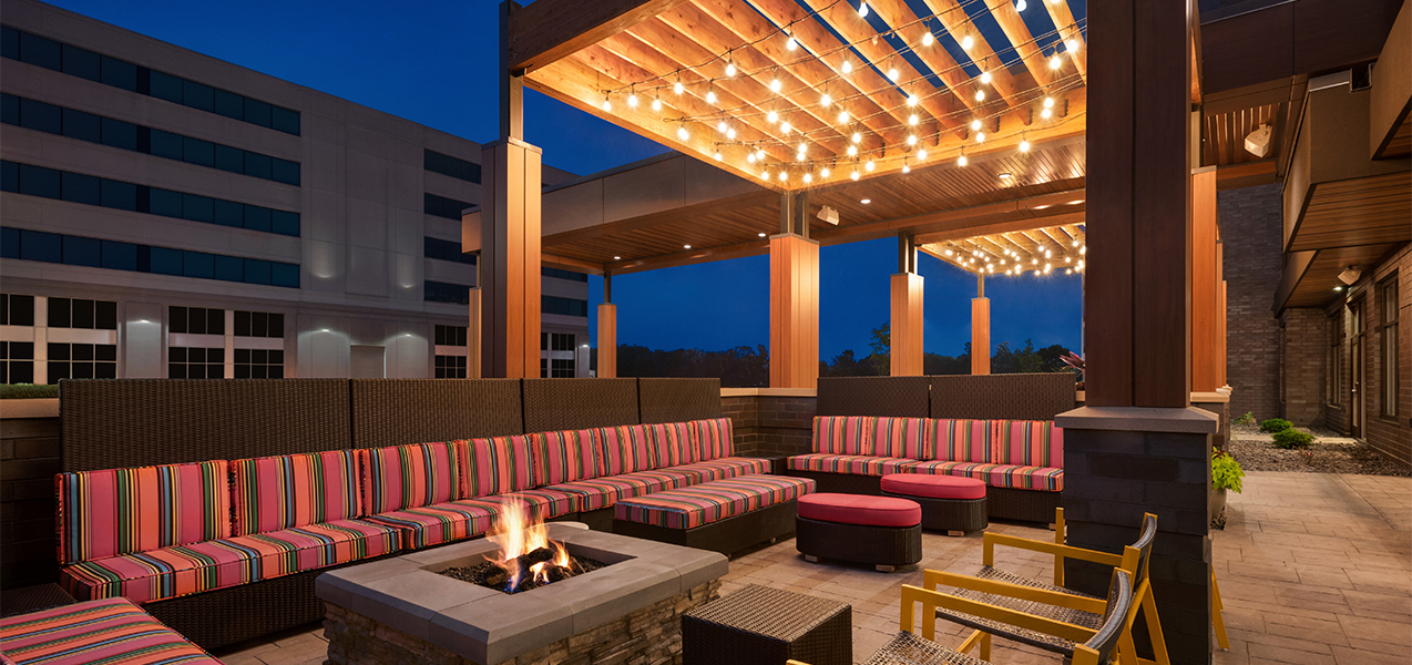 Outdoor seating area and fire pit from the Tri-North Builders Home2Suites by Hilton Madison Central Alliant Energy Center project.