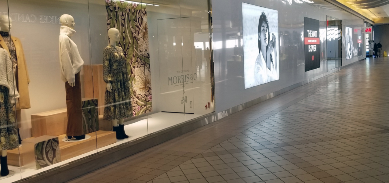 Signage in the windows of an H&M store, located in a shopping mall.