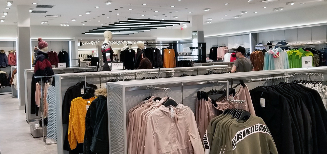 Racks of clothing and mannequins in an H&M store location, a Tri-North project.