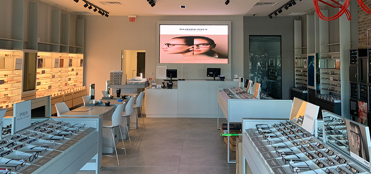 Free-standing cases and backlit wall units display glasses at a LensCrafters location built by Tri-North.