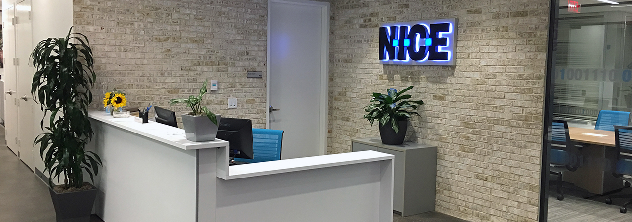 The entrance of the NICE office in Richardson, Texas features exposed brick. This was a Tri-North Builders project. We can help you with your project, too.