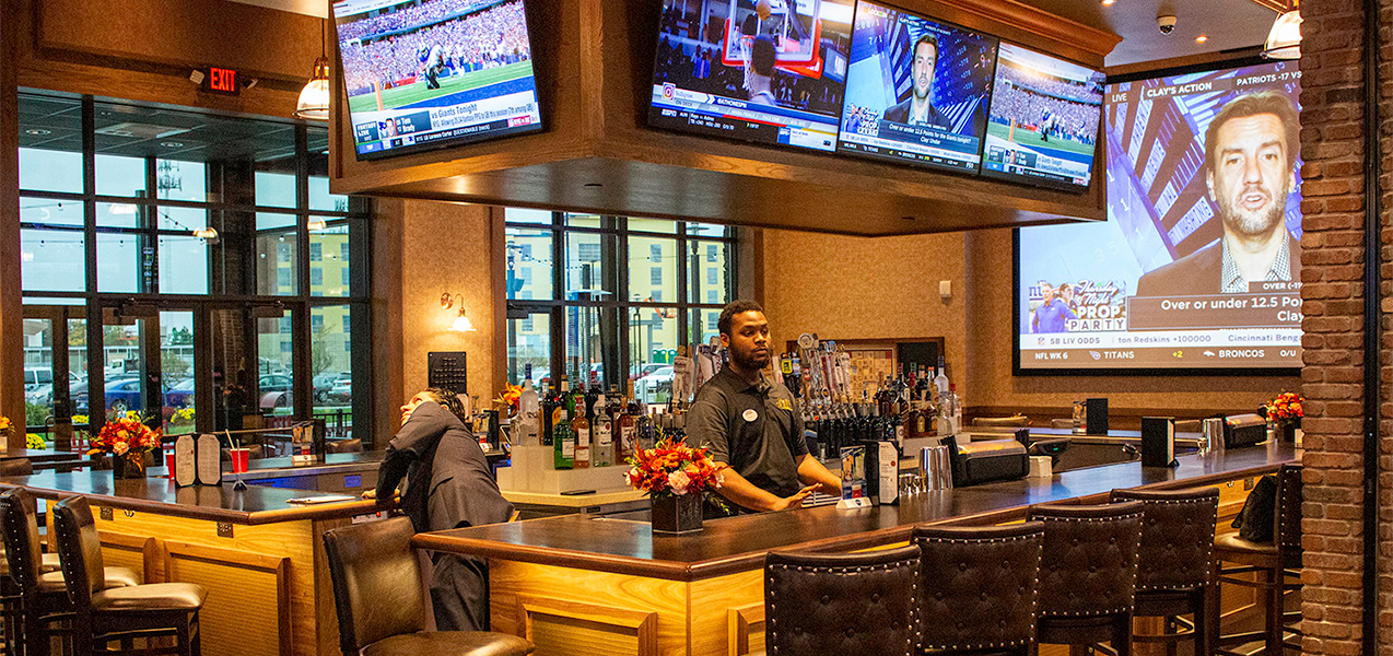 Full bar, bartenders, barstools and television screen in lounge area of the Movie Tavern Brookfield.