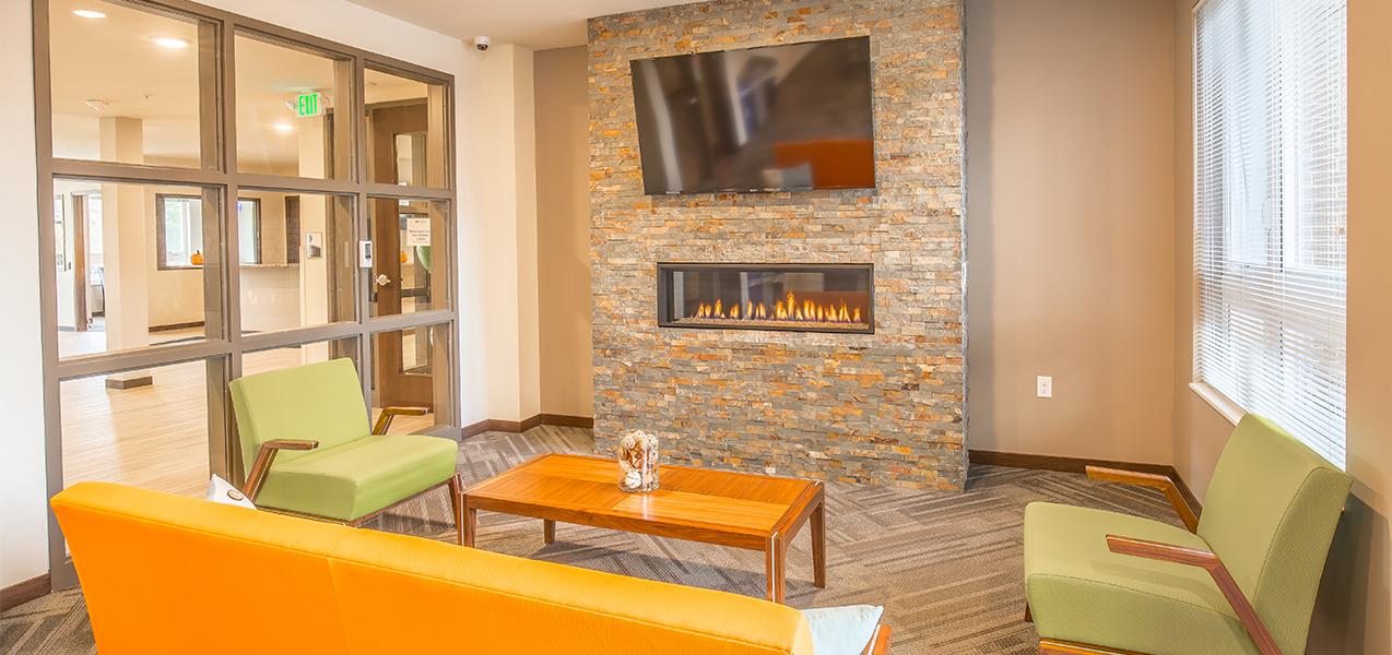 Sitting area with chairs and television inside the Veritas Village apartment complex in Madison, Wisconsin.