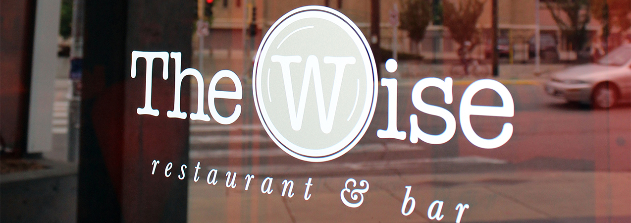 Close up of The Wise at Hotel Red restaurant logo on window in Madison, WI, a Tri-North Builders project.